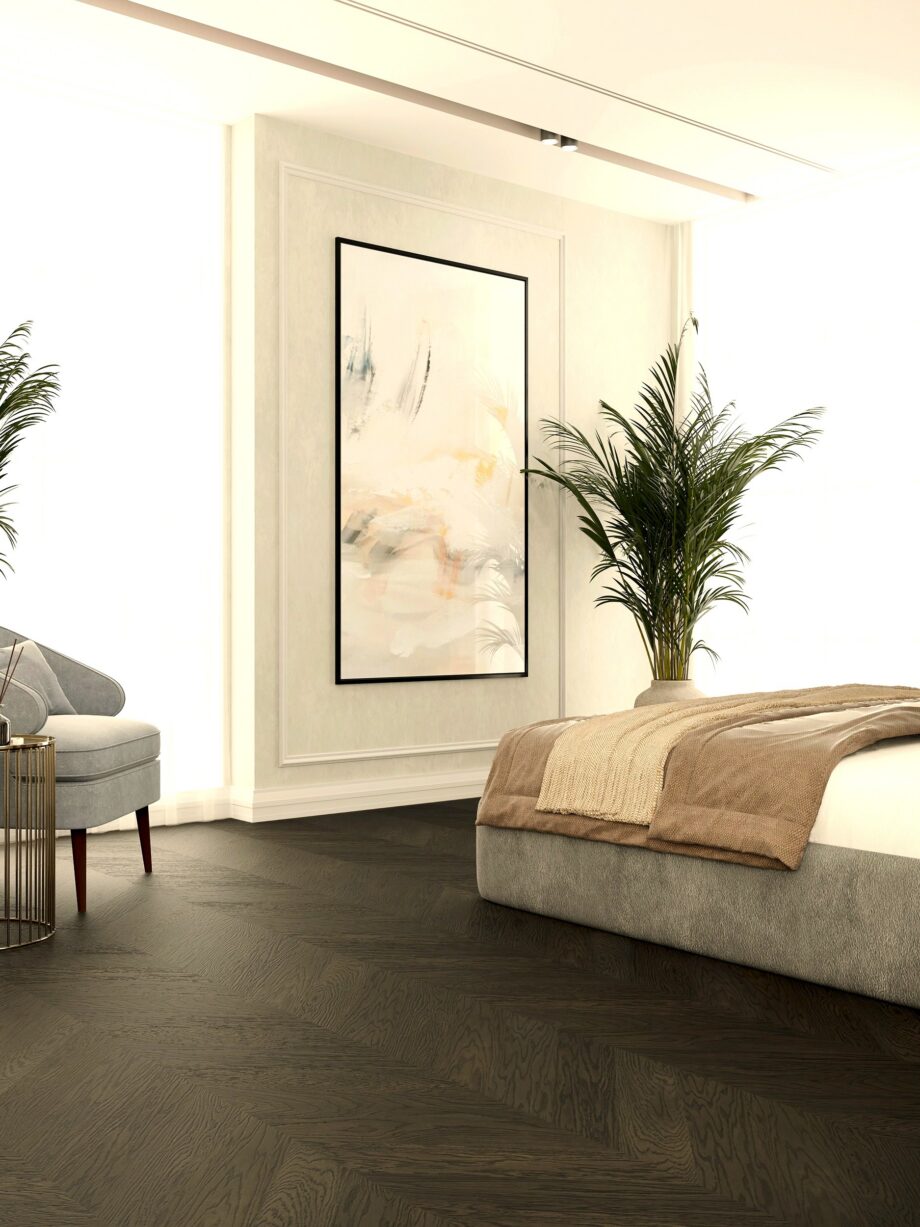 chevron-parketti-tammi-nature-harjattu-viistetty-antrasiitin-harmaa-mattalakka Chevron parketti tammi Nature harjattu viistetty antrasiitinharmaa mattalakka, asennettu makuuhuoneen lattialle. Sänky, nojatuoli, palmut, maalaus.