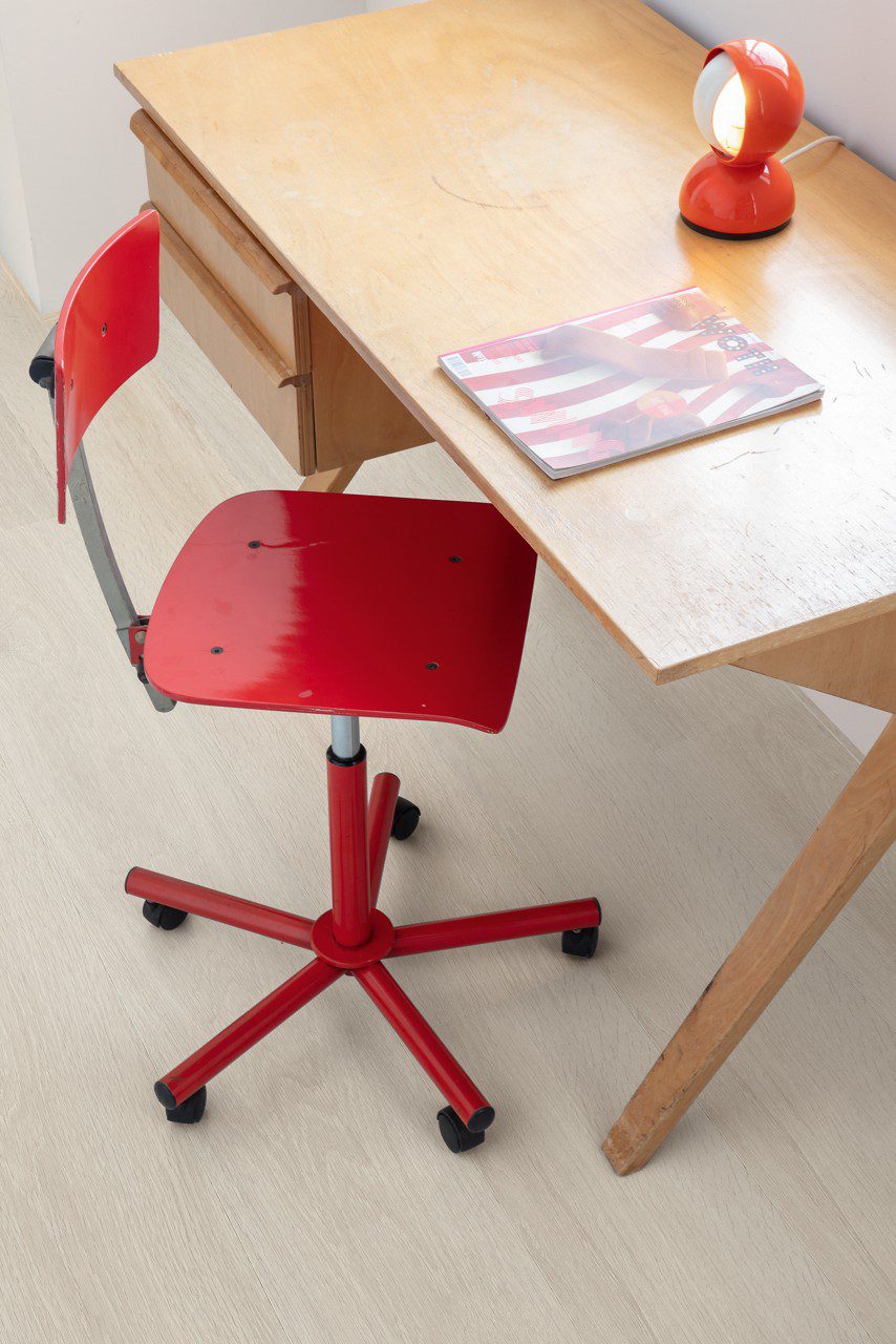 LVT flooring Quick-Step Bloom Sea Breeze Oak Light installed on children's room, desk, red stool.