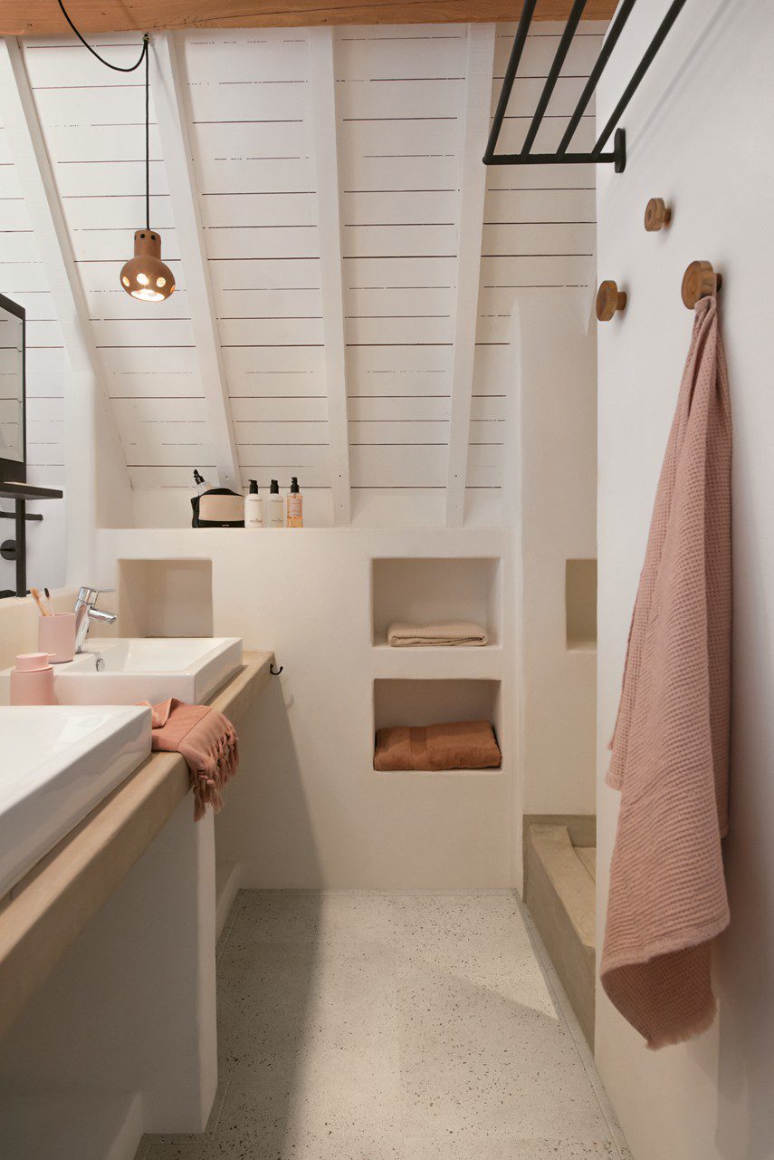 LVT floor Quick-Step Illume Oyster concrete installed on a bathroom floor. Bathroom furniture, towels