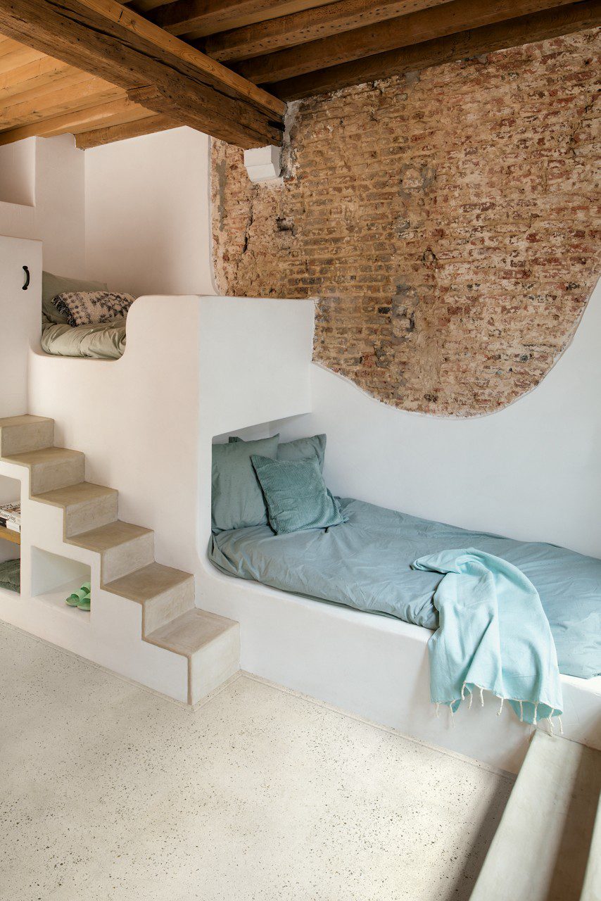 Vinylboden in Betonoptik Quick-Step Illume Pebble Concrete, verlegt im Kinderzimmer – eingebaute Etagenbetten mit Liegeflächen, eine kleine Treppe zum oberen Bett und integrierte Regalfächer unter den Treppenstufen.