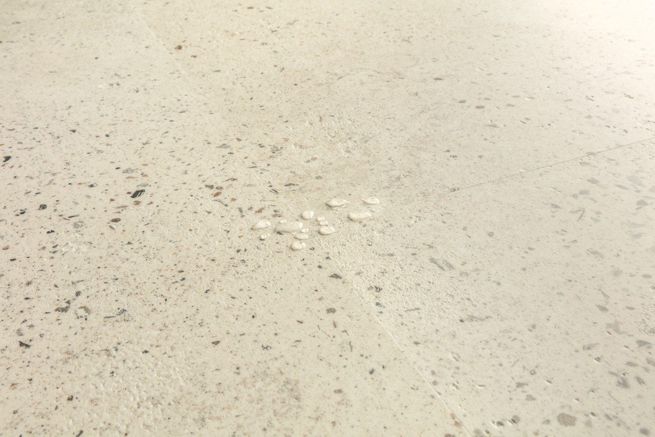 Vinyylilaatta Quick-Step Illume Pebble Concrete asennettuna modernin kodin lattialle – vaalean greige/betoninsävy ja pehmeä, hienovaraisesti elävöity betonikuviointi kivimäisellä tekstuurilla.