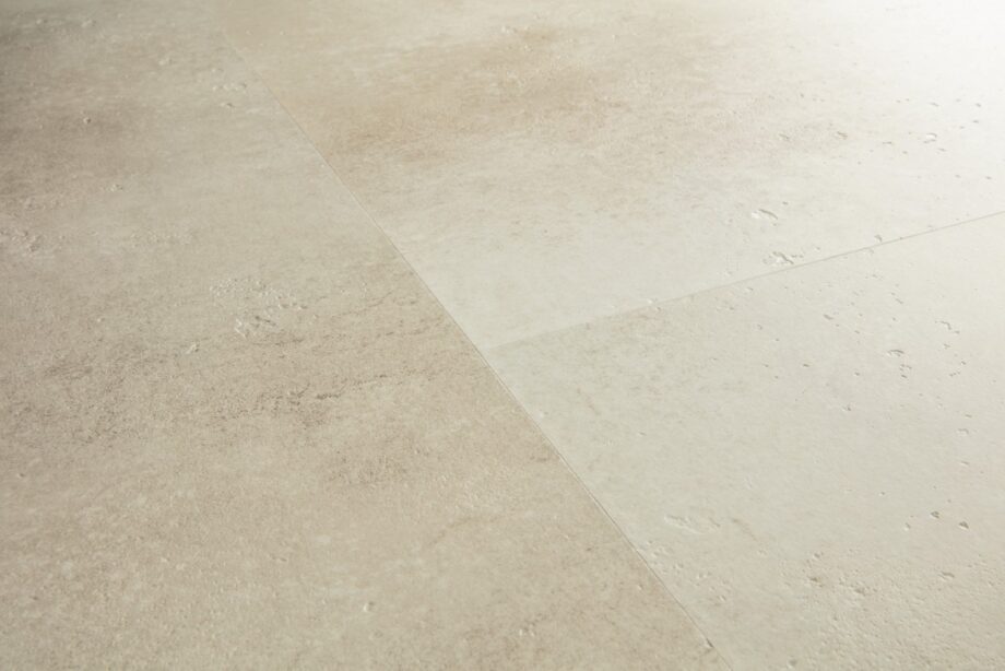 vinyylilattia-quick-step-illume-sandstone-concrete Vinyylilattia Quick-Step Illume Sandstone Concrete asennettuna kodin lattialle – lämmin hiekkabeige/greige sävy ja hillitty, luonnollisen kivimäinen betonidesign hienovaraisella tekstuurilla.