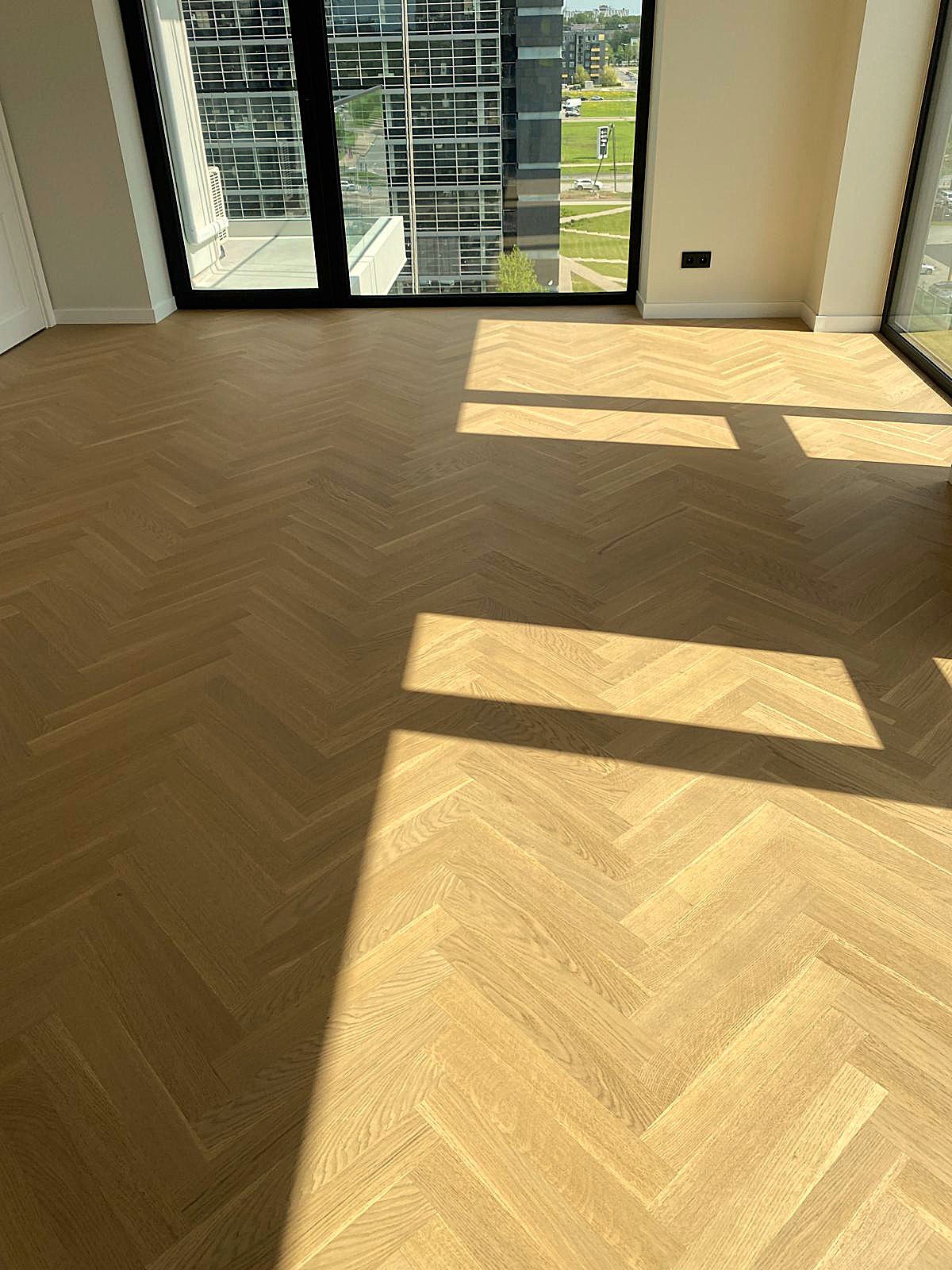 Herringbone parquet Bauwerk Monopark Oak Natur 15 Avorio in a spacious bright room with large windows