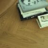 kalanruotoparketti-tammi-rustic-4-sivulta-viistetty-harjattu-2-kerrosta-osmo-oljyvahaa Kalanruotoparketti Tammi Rustic 4 sivulta viistetty harjattu 2 kerrosta Osmo öljyvahaa, asennettu lattialle, kirjat