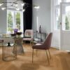 kalanruoto-tammi-mix-viistetty-harjattu-oljyvahaa-180mm Kalanruoto tammi Mix viistetty harjattu öljyvahattu 180mm – luonnollinen sävy ja elävä lajitelma, jossa tammen kauniit syykuviot korostuvat. Asennettu ruokasaliin, jossa on ruokapöytä ja tuolit.