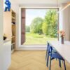 ламинат-елка-quick-step-impressive-design-nutmeg-oak Ламинат ёлочкой Quick Step Impressive Design Nutmeg Oak, уложен на кухонный пол, белый обеденный стол с синими стульями и вазой с цветами