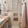 LVT floor Quick-Step Illume Oyster concrete installed on a bathroom floor. Bathroom furniture, towels