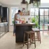 vinyl-flooring-tiles-quick-step-illume-pebble-concrete Vinyl flooring tiles Quick-Step Illume Pebble concrete installed on a kitchen floor. Man is washing apples.