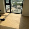 Bauwerk Monopark Oak Natur 15 Avorio herringbone floor in an apartment Herringbone parquet Bauwerk Monopark Oak Natur 15 Avorio installed in a room with a floor-to-ceiling window and sunlight on the floor